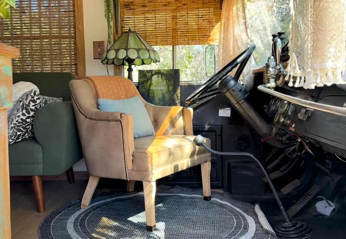 Inside the Time Traveler bus: an armchair beside the old steering wheel