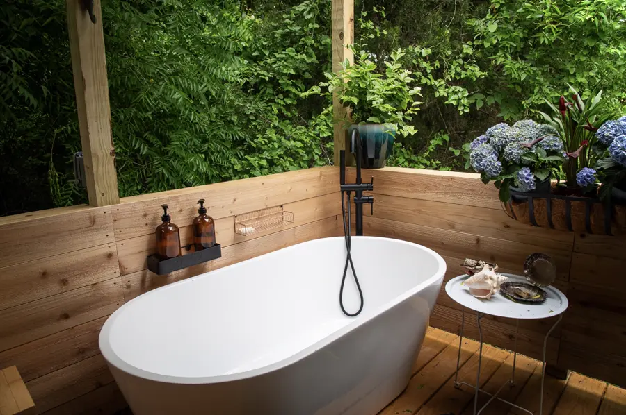 The outdoor tub in the Mermaid Bathhouse, surrounded by greenery and hydrangeas