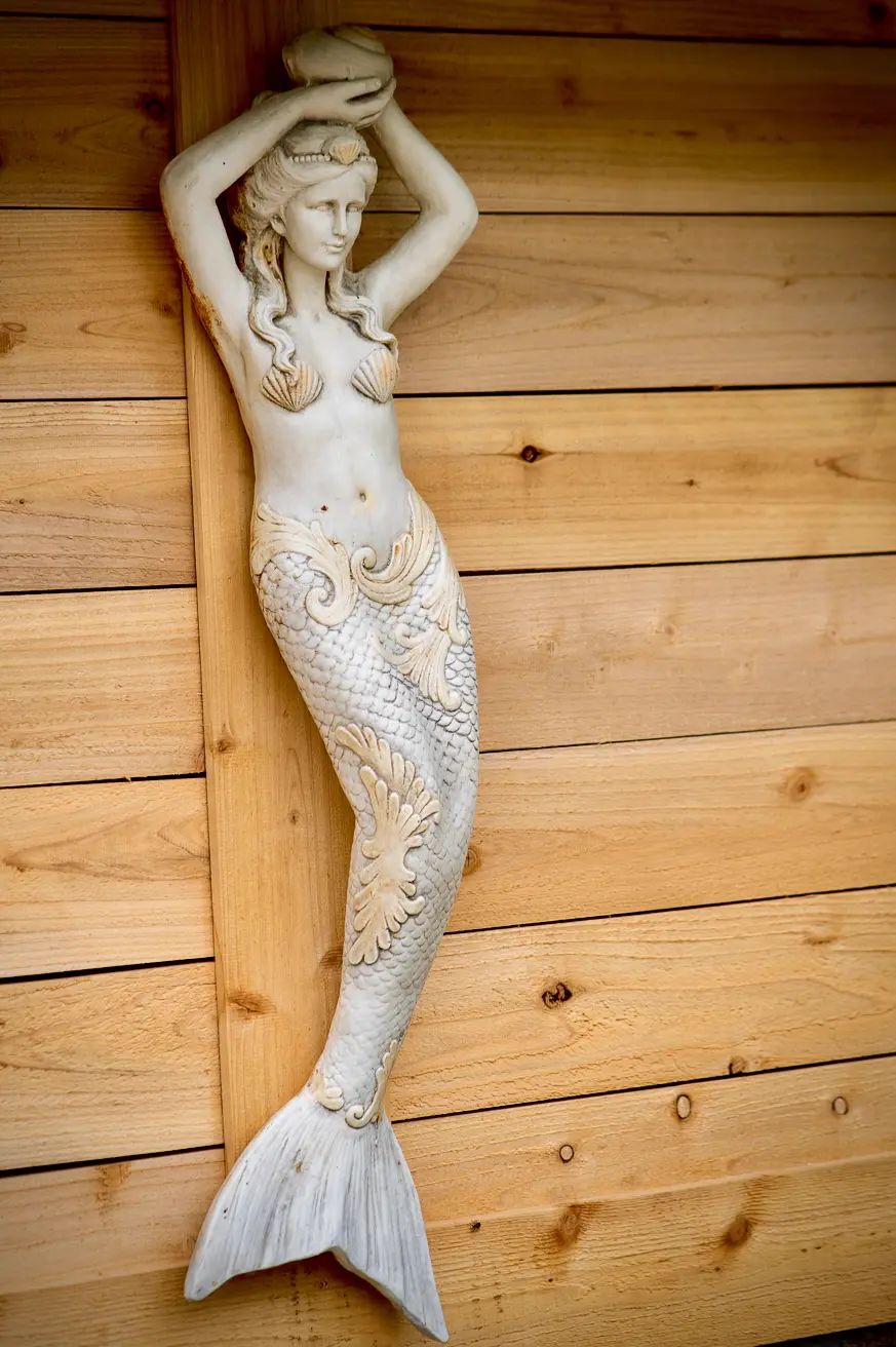 A carved mermaid on the cedar wall of the bathhouse