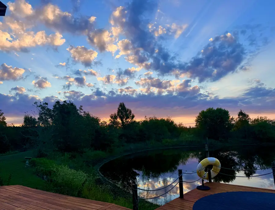 A glowing sunset sky over the pond and dock