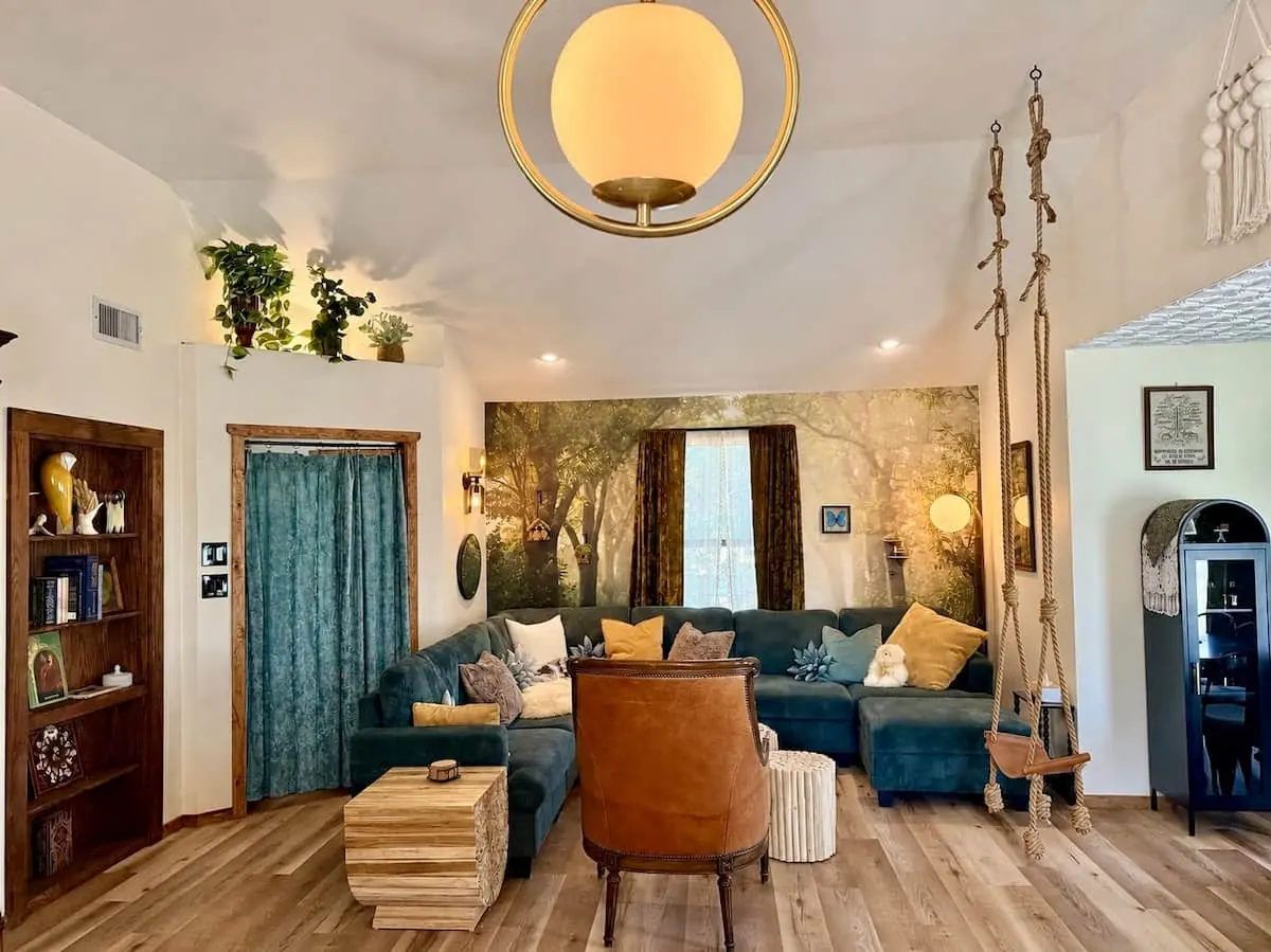 Care Cottage living room with a leather swing and forest mural