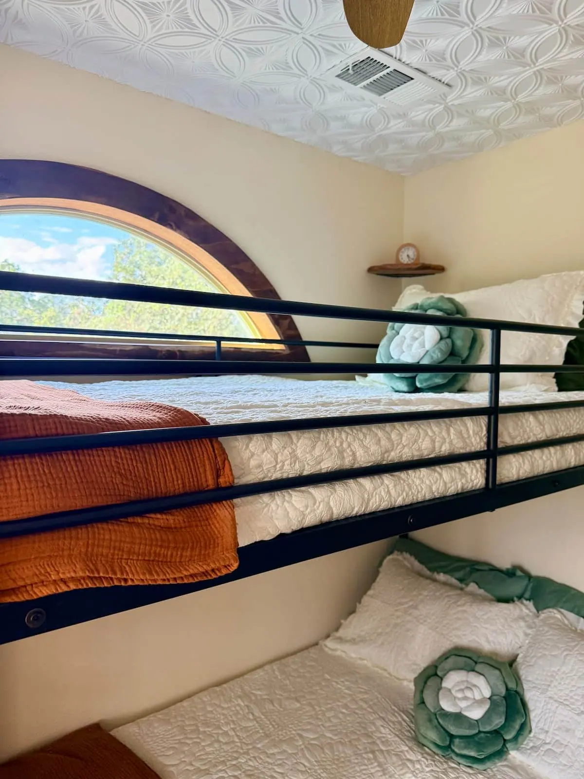 The top bunk beside an arched window