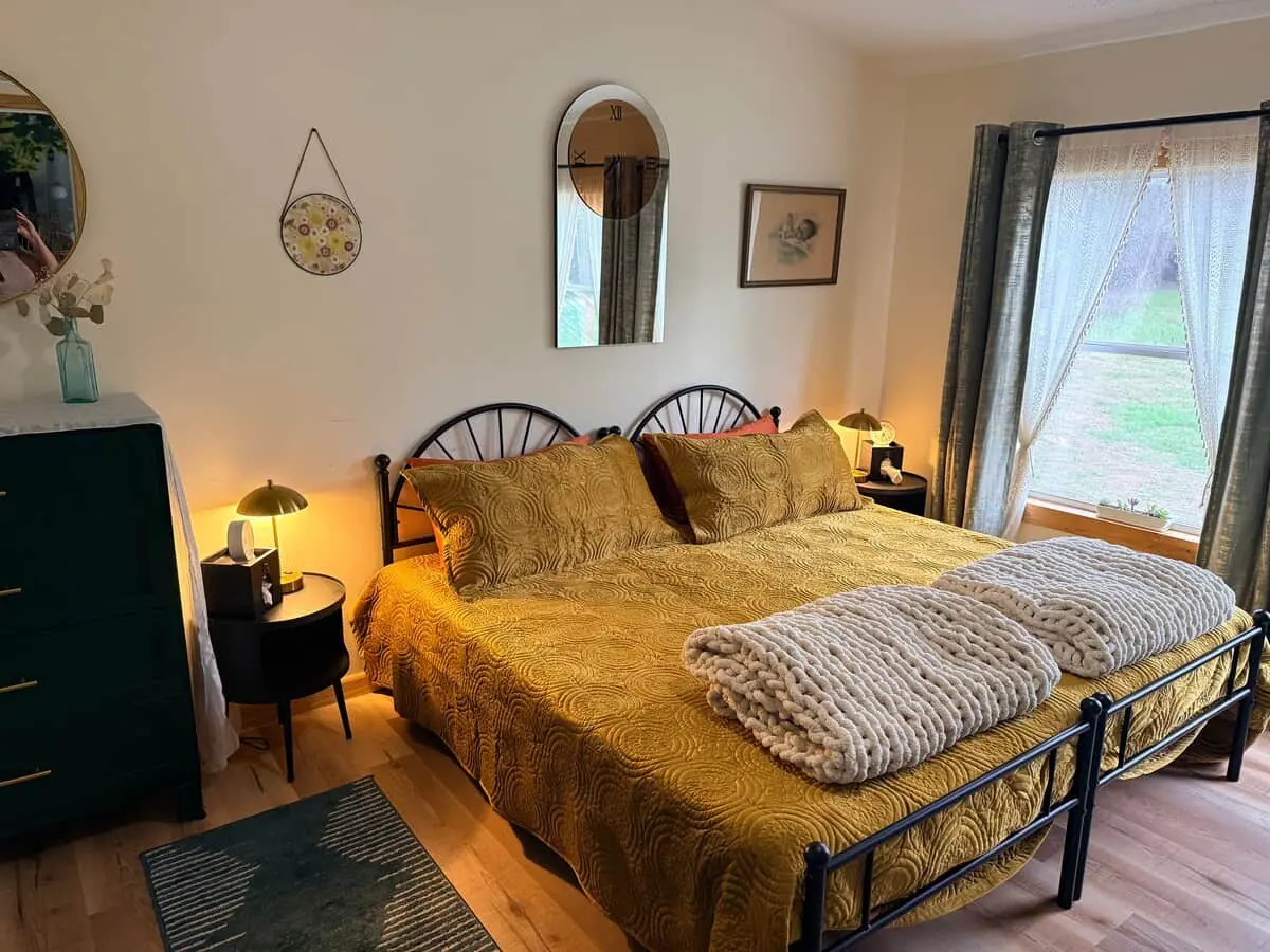 A bedroom with king beds and mustard throws