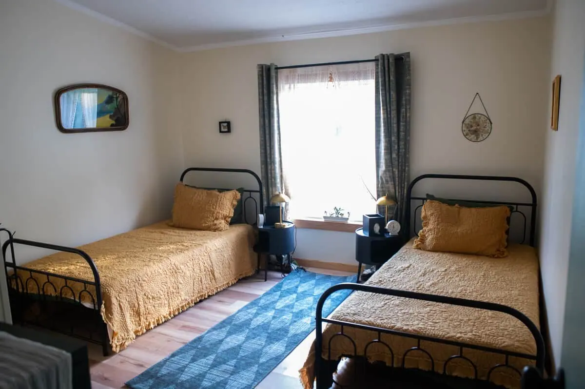 A bedroom with two golden twin beds